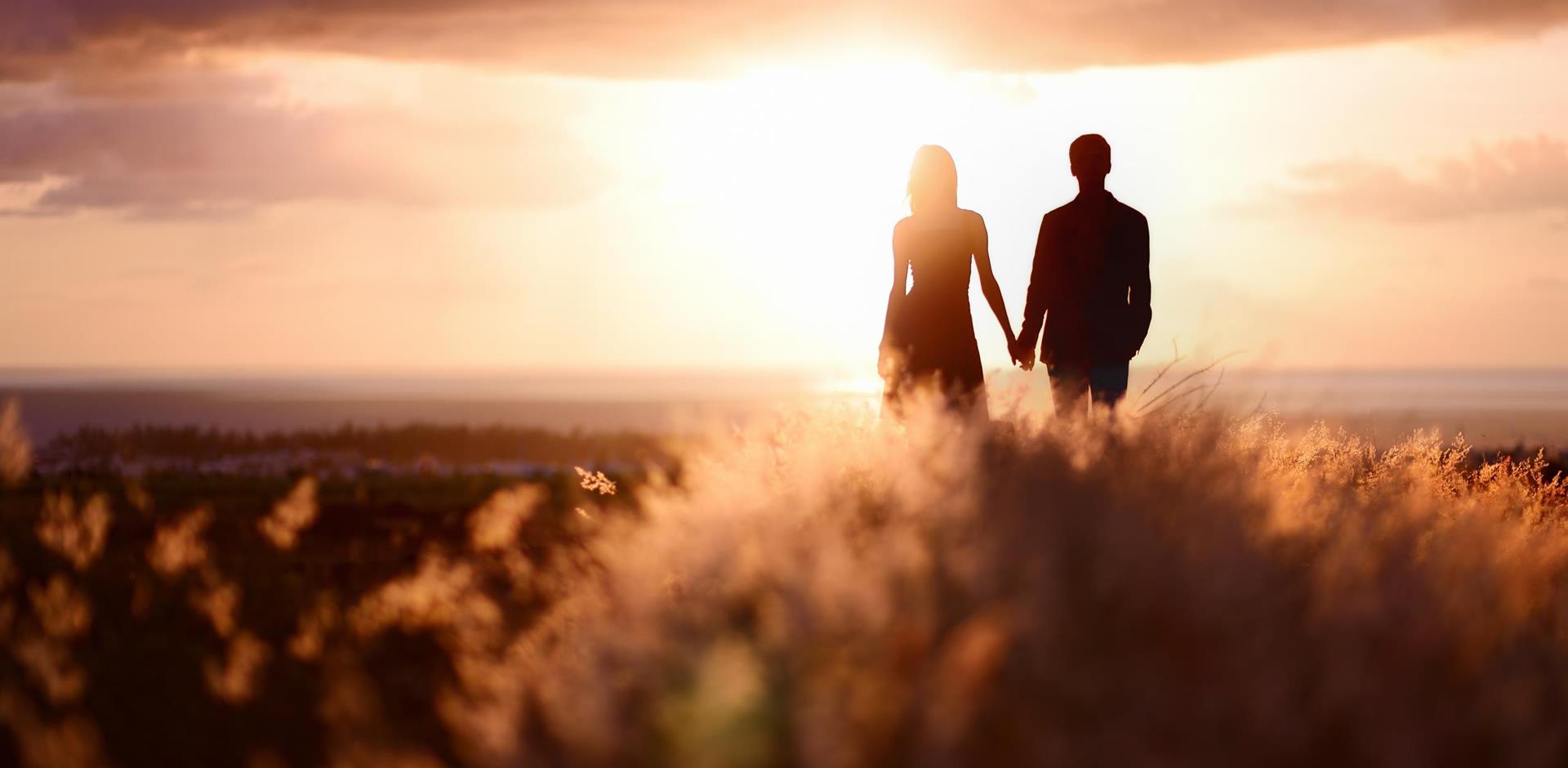 Couple hand-in-hand admiring the sunset