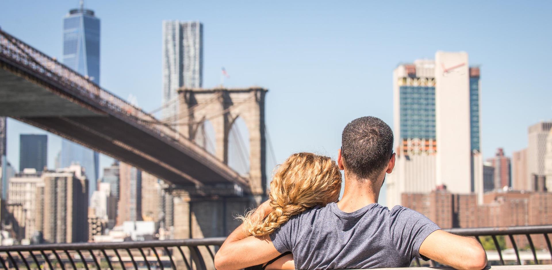 Honeymoon couple on a bench under Brooklyn Bridge, New York