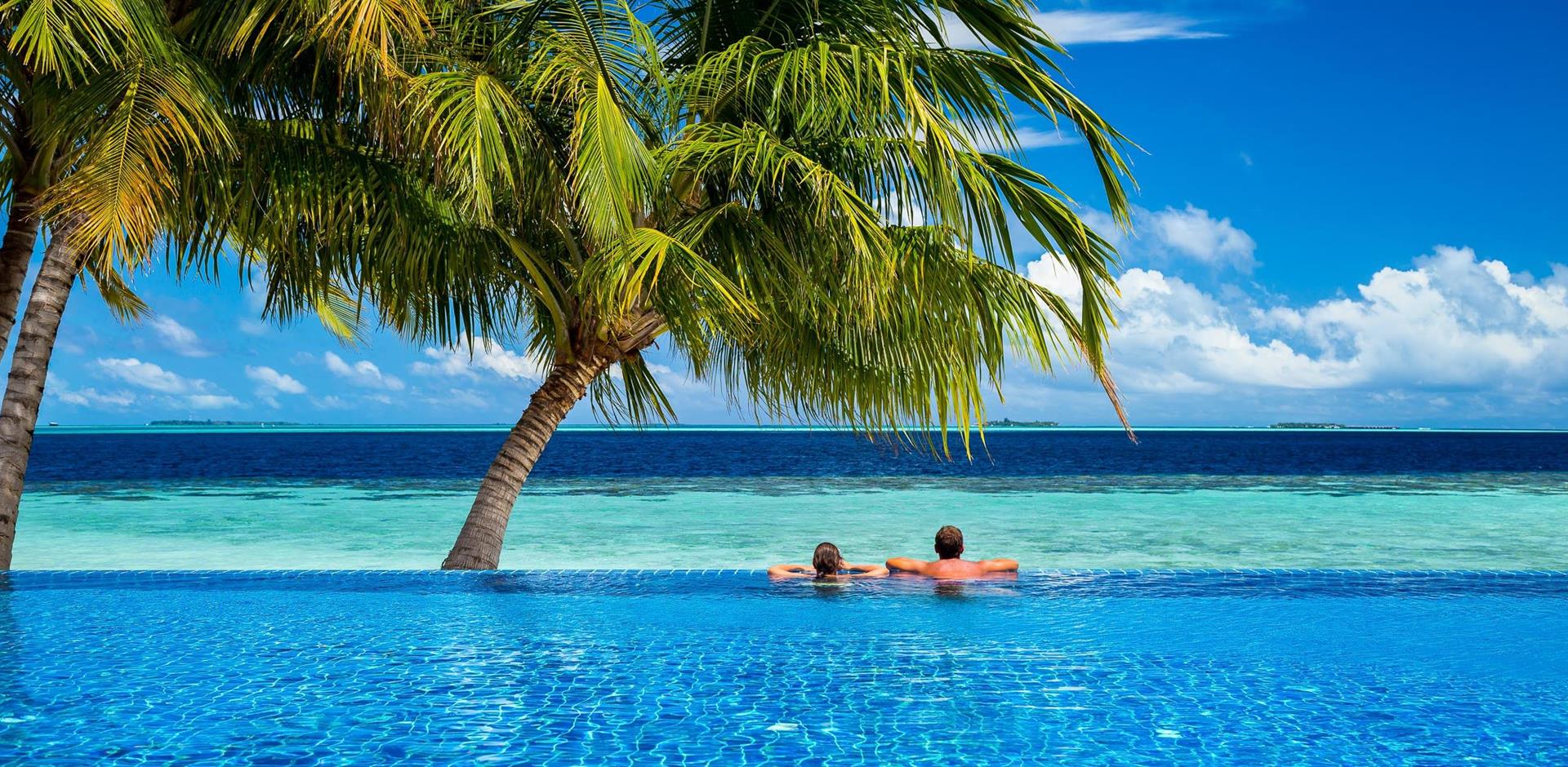 Couple looking out to sea from an infinity pool